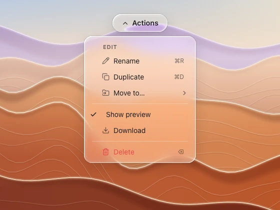 An action menu hanging below its capsule trigger, with icons, shortcuts, dividers and a destructive row, over zoomed desert ridges.